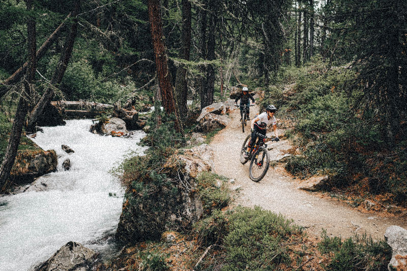 Deux riders qui traversent une rivière en forêt